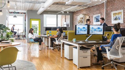 People Working And Collaborating At Their Desks In An Open Office