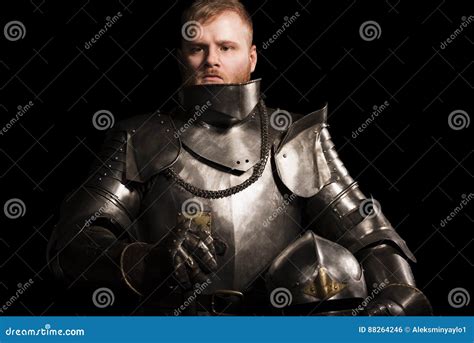 Knight In Armour After Battle On The Black Background Stock Photo
