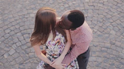 interracial couple bonding and laughing in house home or hotel living room in playful fun or