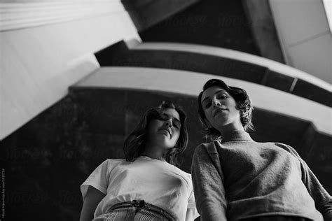 Two Stylish Women Looking Down At Camera From Above By Stocksy