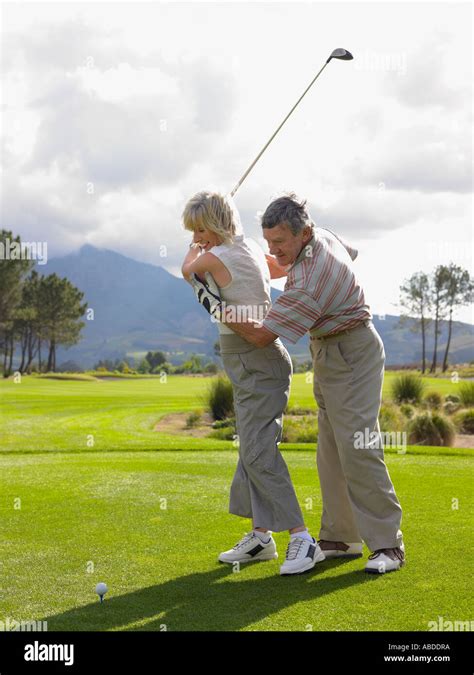 Man Giving Woman A Golf Lesson Stock Photo Alamy