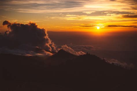 Mountain Peaks In Clouds Against Spectacular Sunset · Free Stock Photo