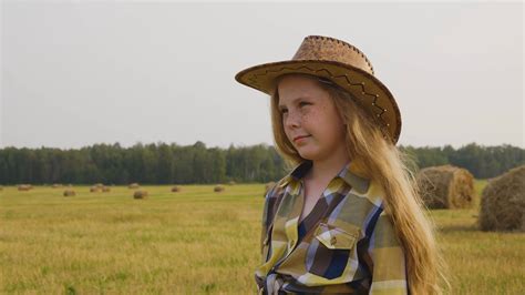 Cowgirl On Countryside Field On Haystack Background Young Cow Girl In
