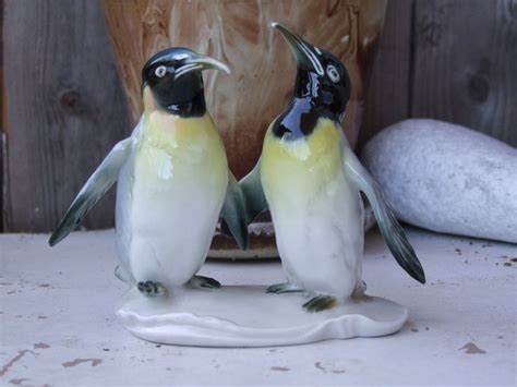 Two Ceramic Penguins Standing Next To Each Other