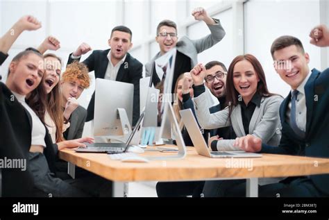 Group Of Happy Office Employees Sitting At A Table Stock Photo Alamy