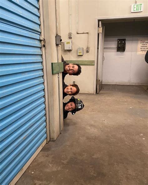 Three Men Standing In Front Of A Blue Storage Door With Their Heads