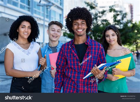 ラテン系、ヒスパニック系、白人系の学生が集まるアフリカ系アメリカ人の学生で、夏の都市の屋外にいる写真素材1532998703