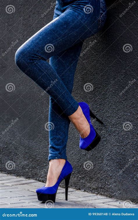 Beautiful Slender Female Legs In Tight Jeans And Blue Velvet High Heeled Shoes Slipped Stock