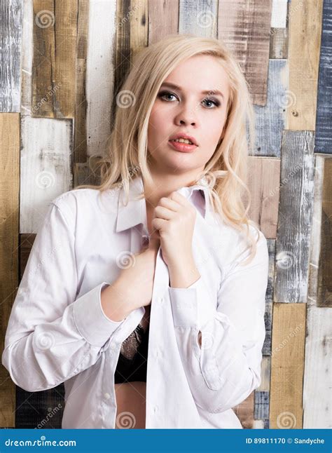 Portrait Of Attractive Blonde Girl Standing On Wood Wall Background She Has Blue Eyes And