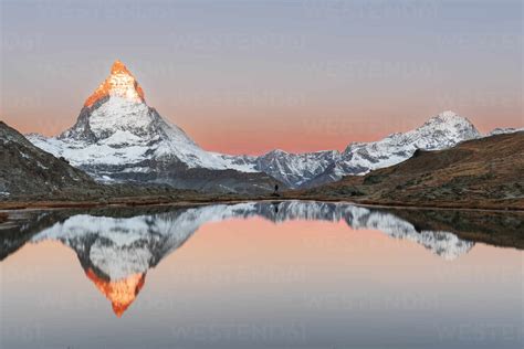 Hiker Admiring The Matterhorn Reflected In The Riffelsee Lake At