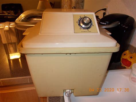 An Old Fashioned Washing Machine Sitting On Top Of A Counter
