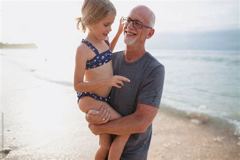 Active Happy Grandpa Having Fun With Granddaughter On Beach Vac By