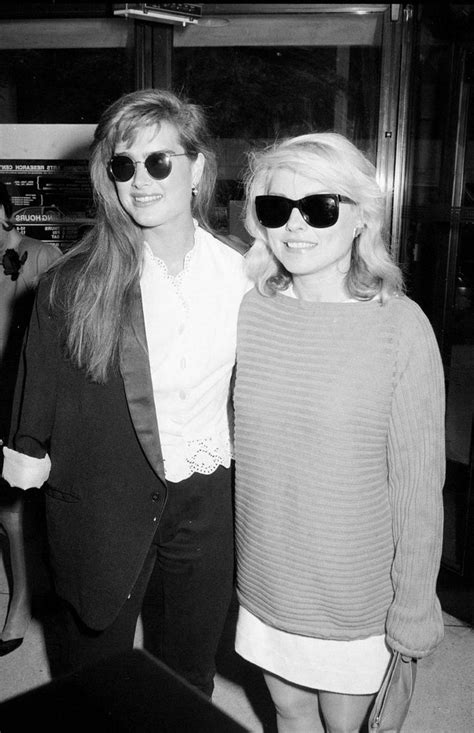 Two Women Standing Next To Each Other Wearing Sunglasses