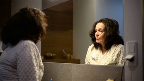 Woman Standing In Front Of The Mirror In The Bathroom And Looks Tired