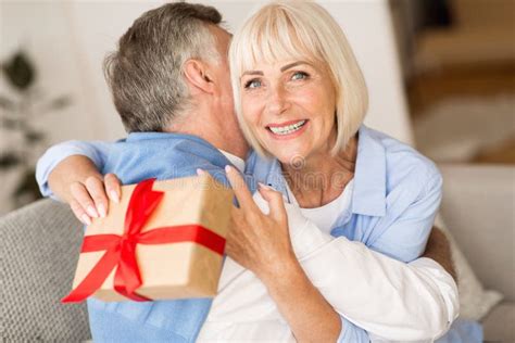 Present Of Love Senior Woman Making Surprise For Husband Stock Photo