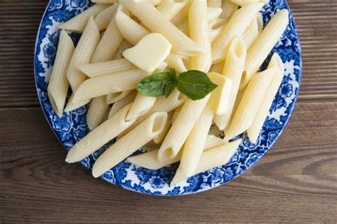 Cooked Penne Pasta With Butter And Cheese And Basil In Vintage