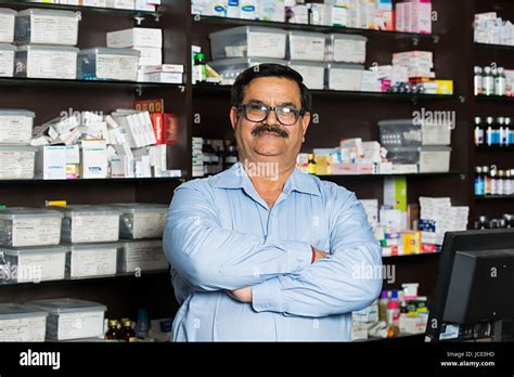 1 Indian Shopkeeper Man Arms Crossed Standing In Chemist Store Keeper