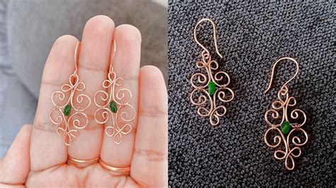 A Person Holding Two Pairs Of Earrings In Their Hand Next To Another