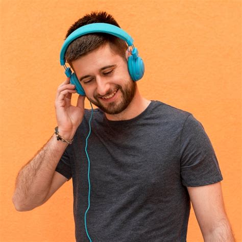 Beau Mâle écoute De La Musique Dans Les écouteurs Photo Gratuite