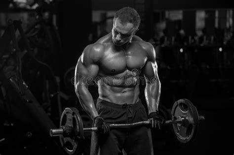 Handsome Man With Big Muscles Trains In The Gym Exercises Stock Image