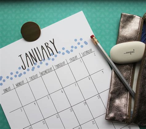A Calendar With A Pen And Pencil On Top Of It Next To A Purse That Says