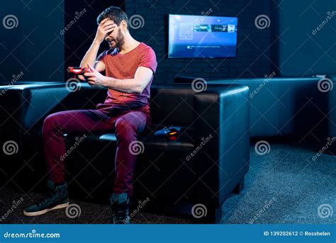 Sad Man Playing Video Games With Gaming Console In The Club Stock Photo