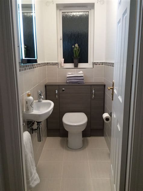 Small Cloakroom Grey Lined Wall And Floor Tiles Edged With Mosaic