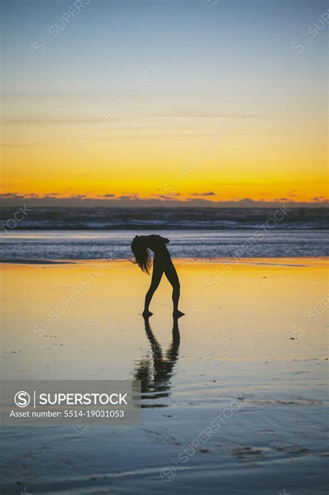 Naked Female Posing On The Beach At Sunset Superstock
