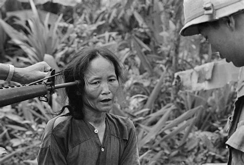 Two South Vietnamese Soldiers Question A Suspected Viet Cong Women At