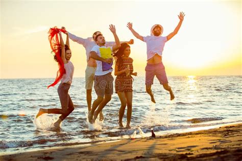 Group Of Happy Young People Dancing At The Beach On Beautiful Summer