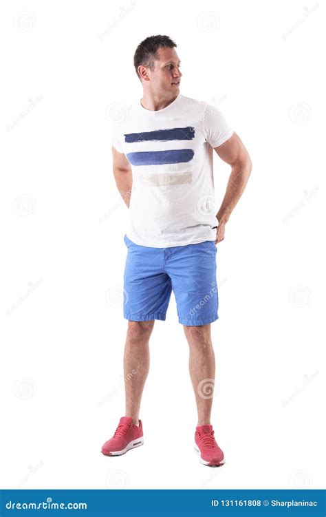 Young Adult Man With Arms Behind In White T Shirt And Blue Shorts