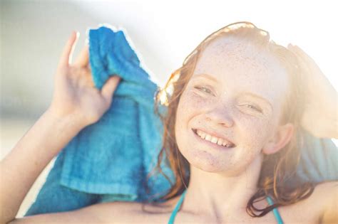 Portrait Of Smiling Girl On The Beach Drying Her Hair With A Beach