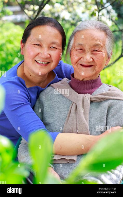 Picture Of One Mature Chinese Woman With Her Senior Mother Outdoor In