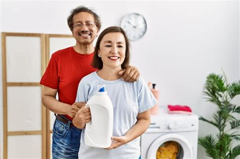 Premium Photo Middle Age Interracial Couple Doing Laundry Holding