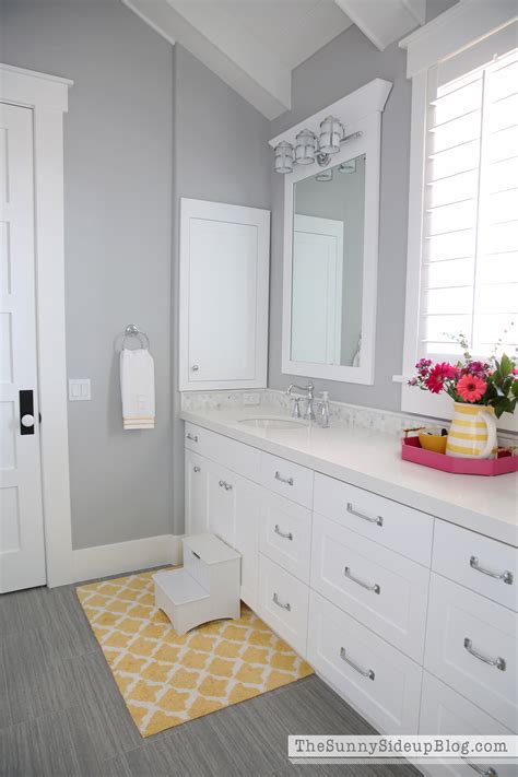 This grey and white master bathroom uses a darker floor tile to visually anchor light walls. Girls' bathroom decor - The Sunny Side Up Blog