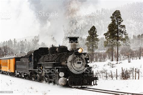 Vintage Steam Train Billowing Smoke In The Snow As It