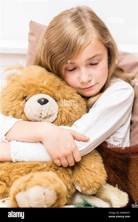 Sad Little Girl Cuddling With Her Teddy Bear Studio Shot Stock Photo