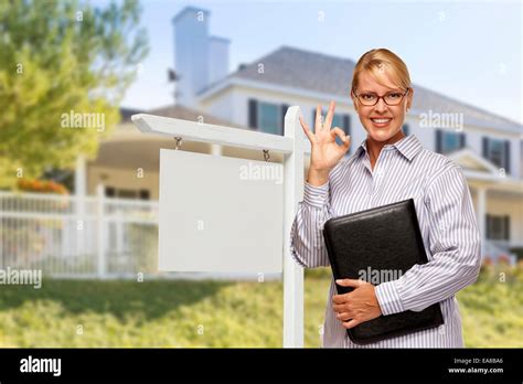 Attractive Female Real Estate Agent In Front Of Blank Real Estate Sign And House Stock Photo Alamy