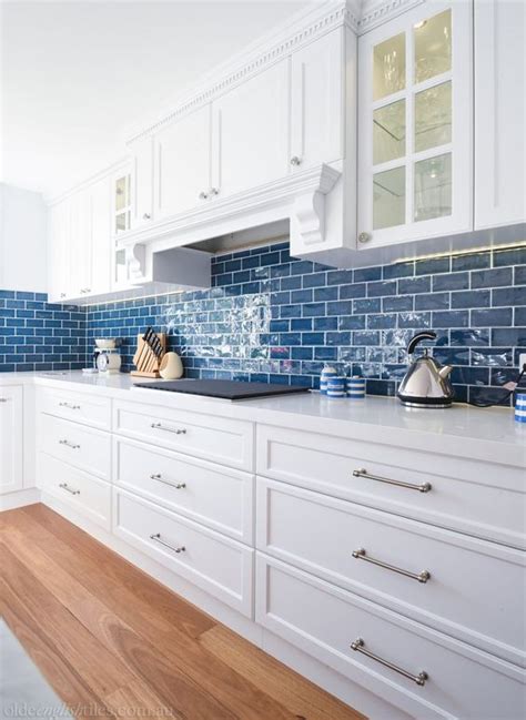 A Cozy Coastal Kitchen In White With Bold Blue Subway Tiles That Add