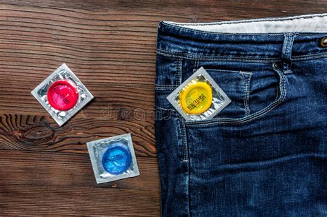 Безопасный секс с контрацепцией презерватива в джинсах Pocket на деревянном взгляд сверху