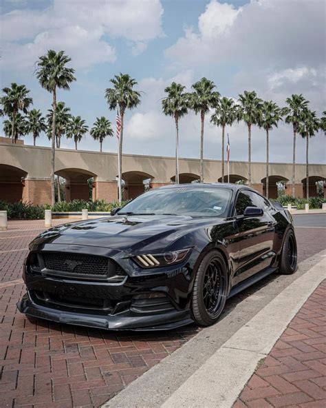 A Black Mustang Parked In Front Of A Building