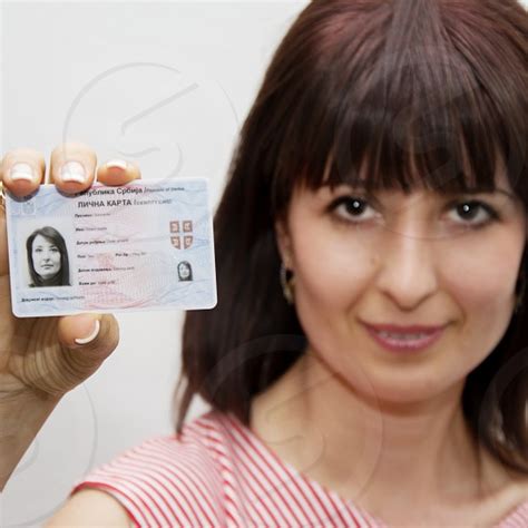 Woman Holding Her Id Card In Front Of Herself By Newnow Photography By