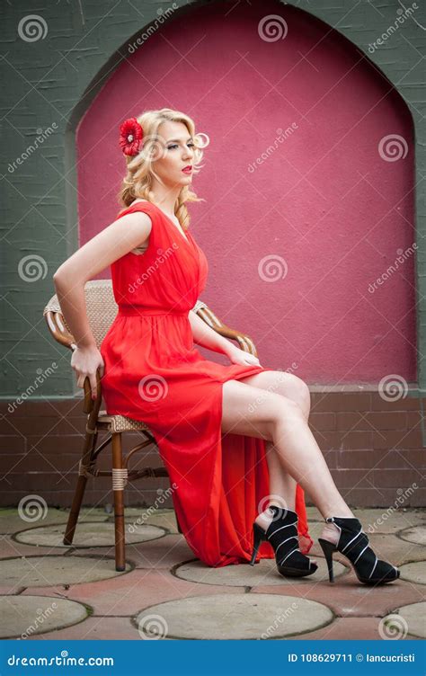 Donna Bionda Attraente Alla Moda In Vestito Rosso Che Si Siede Sulla Sedia Bella Donna Elegante