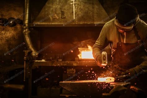 The Blacksmith Forging The Molten Metal On The Anvil In Smithy Photo By