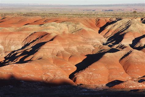The Desert Is Covered In Red And Brown Rock Formations With Sparse