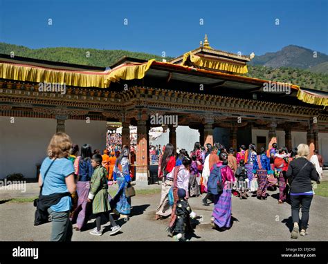 bután los bhutaneses en traje tradicional y turistas en trashi chhoe dzong para un día de