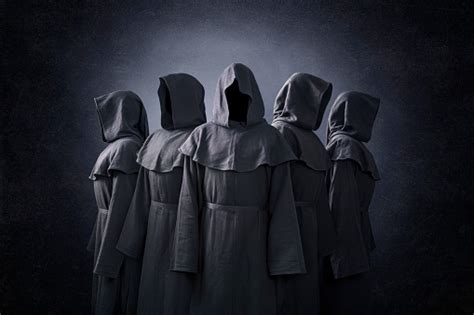 Group Of Five Scary Figures In Hooded Cloaks In The Dark Stock Photo