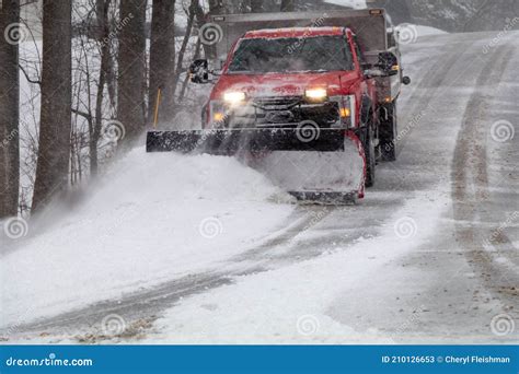 Snowplow In Action Clearing Residential Roads During Snow Storm Stock