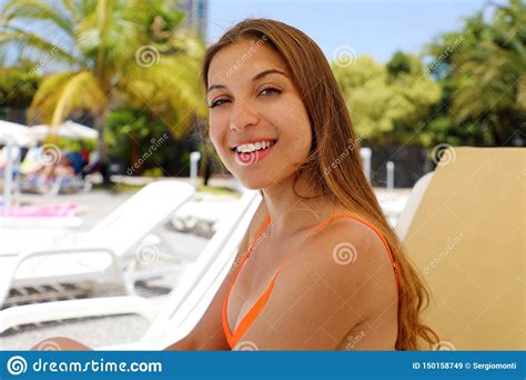 Happy Smiling Woman Sitting On Deck Chair In Tropical Pool Laughing Girl Enjoying The Sun On