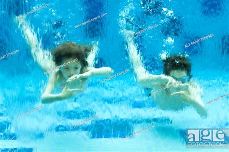 Brother And Babe Swimming Underwater In Swimming Pool Hands Forming Finger Frames Stock